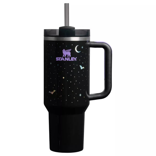 Limited edition Stanley Quencher H2.0 40 oz tumbler in a black night sky print, featuring white and iridescent stars, a crescent moon, and bats. The tumbler has a black handle with a purple comfort grip and a dark gray straw.